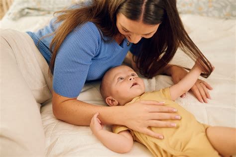 mama drži dojenčka s primerno avtentično ninico